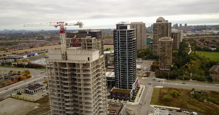 Drone flight over a growing city with new condominiums under construction.