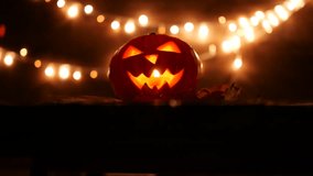 Carved Halloween pumpkin with lights on background. Dark key footage in UltraHd resolution. 4k video footage