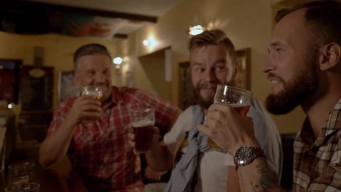 Good old friends drinking beer in a pub