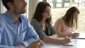 Focused students listening and taking notes in the classroom. Attentive positive people learning a subejct in college. - Powered by Shutterstock - Get 15% off with code: PIKWIZARD15