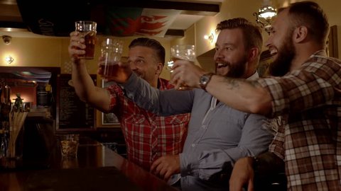 Good old friends drinking beer in a pub