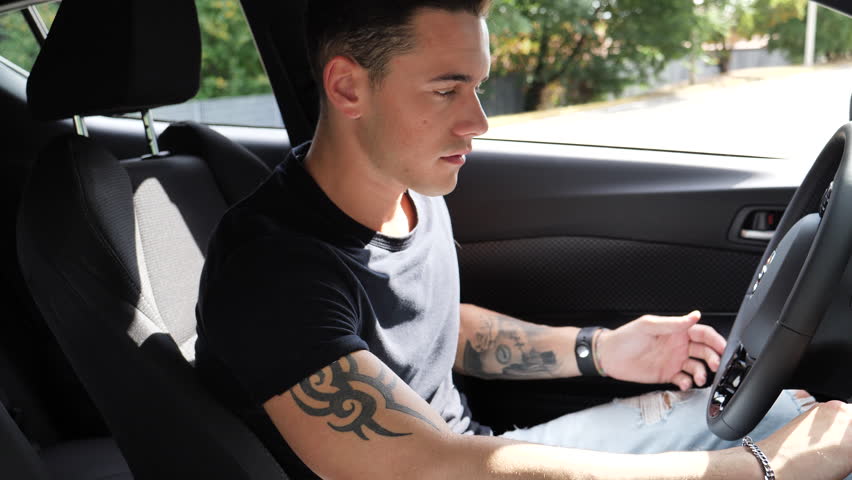 Young handosme man in his car, reclining the seat and getting to sleep, exhausted, tired