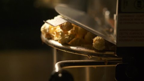 Fresh roasted pop corn pop out of the bowl - pop corn maker in a movie theater