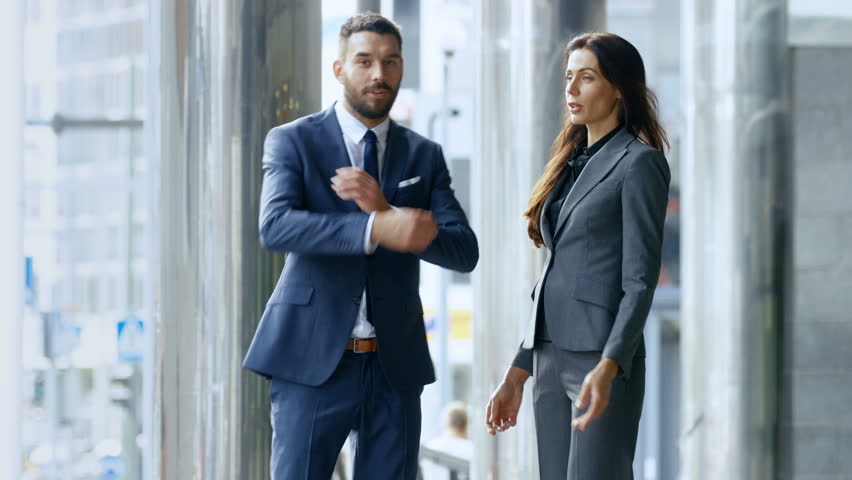 Male and Female Business People Cross Arms and Smile While Standing in the Middle of the Central Business District Street.  Shot on RED EPIC-W 8K Helium Cinema Camera. | Shutterstock HD Video #31601200