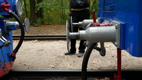 Standard type of connection between cars train on railways with buffer and chain coupling. Traditional hook coupler wagon hitch. Connecting coupling device between railway cars on train at rail track