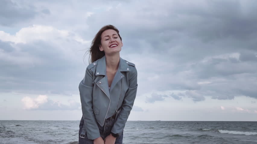 Beautiful, happy girl jumping for joy on the beach in a warm spring day. she is happy and cheerful