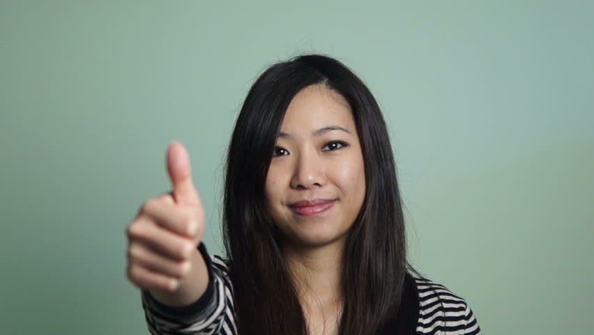 Asian girl doing a thumb up gesture.