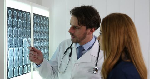 Neurosurgeon Man Give Bad News Diagnostic to a Young Female Look Brain Mri Scan, videoclip de stoc