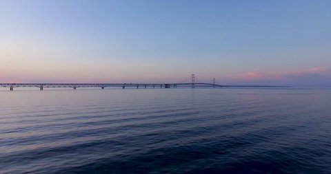 Slow rippling waves with sunset and Mackinac Bridge in the background
