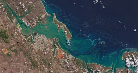Very high-altitude overflight aerial of the coastland and water off Gladstone, Australia. Clip loops and is reversible. Elements of this image furnished by NASA