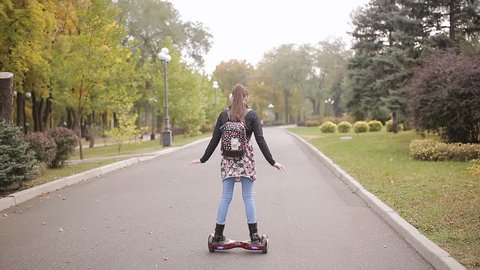 girl riding portable electronic hyroscooter outdoors