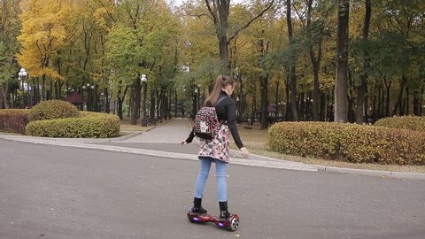 girl riding portable electronic hyroscooter outdoors
