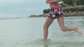 Joyful happy young girl running on the water sea spray slow motion stock footage video