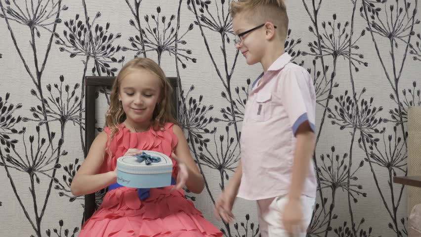 Cute boy presents a gift to the girl