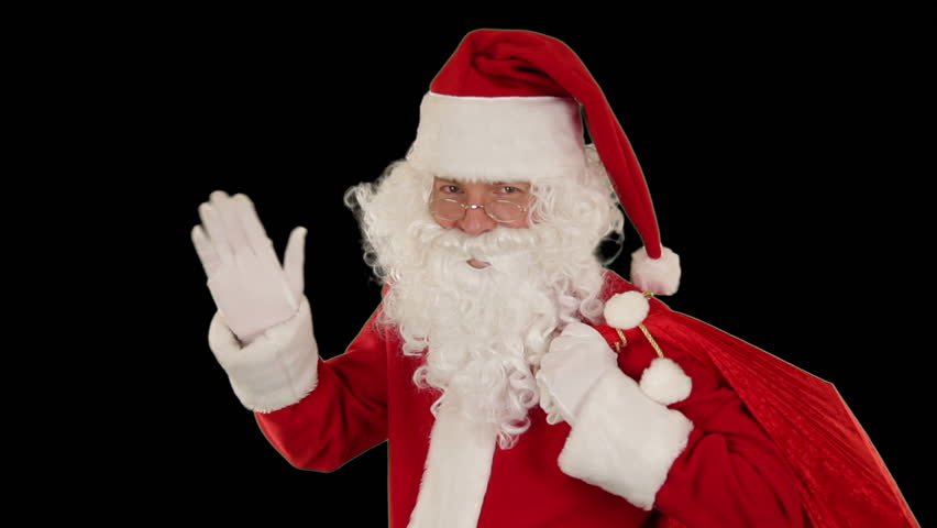 Santa Claus carrying his bag, looks at the camera sends a blow kiss and wave,