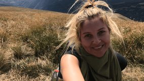 Pretty woman films nature after hiking 4K 2160p 30fps UltraHD footage - Female hiker takes selfies on mountain peak close-up 3840X2160 UHD video
