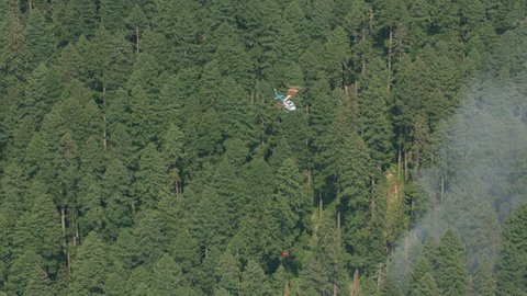 Oregon circa-2017, Aerial shot of helicopter dropping water on forest fire. Shot with Cineflex and RED Epic-W Helium.