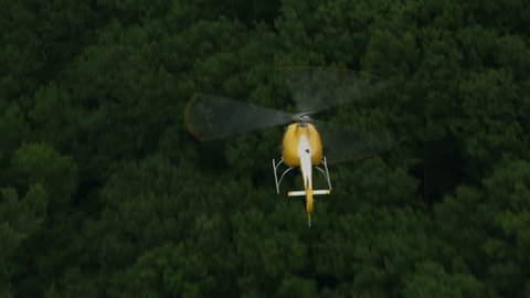 Closeup aerial shot of helicopter flying over trees. Shot with Cineflex and RED Epic-W Helium.