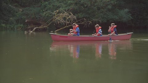Kids at summer camp paddling a canoe