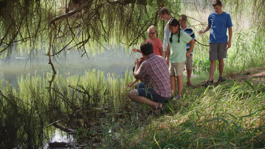 Kids at outdoor school get water samples from pond