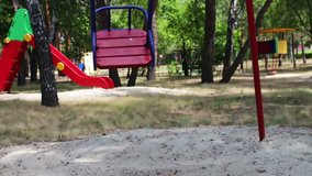 Red children's swing swings from side to side