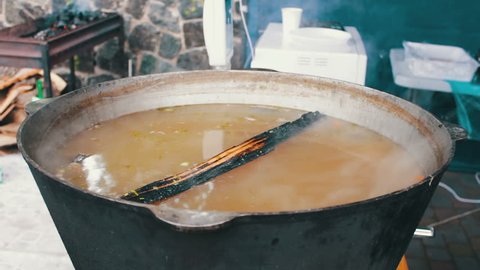 A huge bucket of soup is brewed at a food festival