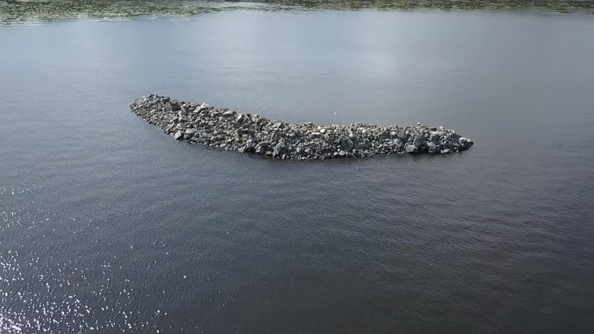 Rock Island on lake - slow motion aerial shot