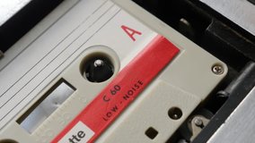 Music archives playing from cassette in casettophone close-up 4K 2160p 30fps UltraHD footage - Shallow DOF audio tape player supply spindle 3840X2160 UHD video