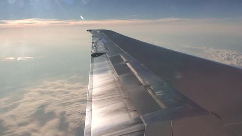 View of airplane wing from inside airplane whilst flying