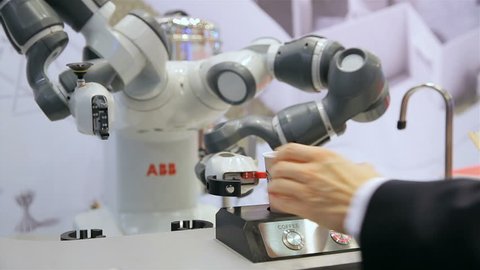 HELSINKI, FINLAND - OCTOBER 10, 2017: Robot with flexible hands makes a coffee. Latest technology in the field IoT, VR, AR, Big Data on the Trade Fair TEKNOLOGIA 17 in Messukeskus expo center.