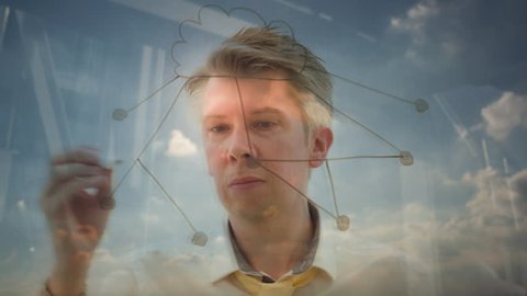 Reflection of a creative businessman brainstorming drawing an image of a cloud network global communication concept backlit against the sun ithemes of networking the cloud and data