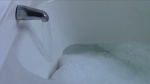 Bathtub filling with water and soap suds