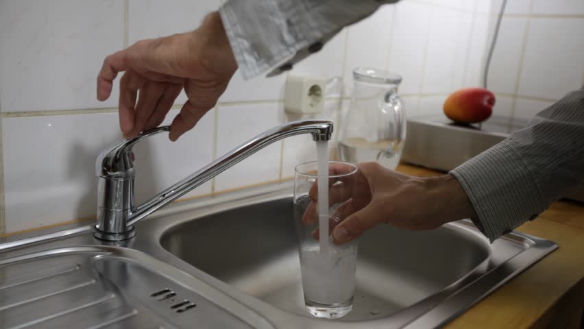 Tap water is poured into a glass