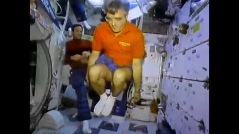 CIRCA 1992 - Astronauts jump rope, drink floating droplets and perform a zero gravity magic trick aboard Space Shuttle Endeavor as it orbits the earth.