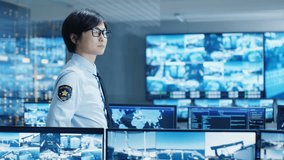 In the Security Control Room Officer Monitors Multiple Screens for Suspicious Activities. He Guards Internationally Important Logistics Facility. 