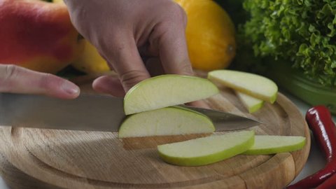 Man's hands cutting apple into pieces