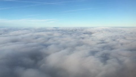 Vast Banks of Clouds float by, viewed from the window of a commercial passenger airline (4K)