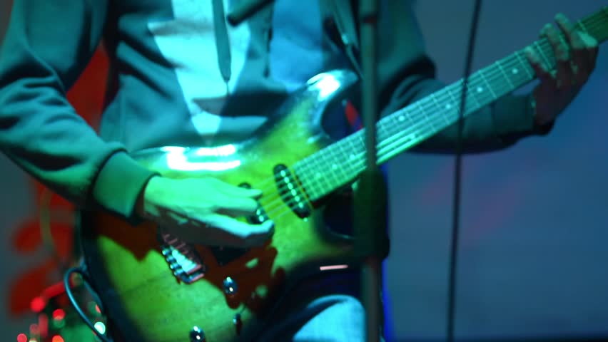 A man plays an electric guitar at a concert