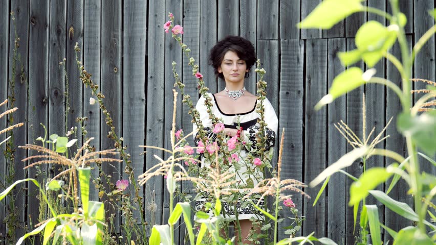 The Ukrainian girl stands on the background of the barn.