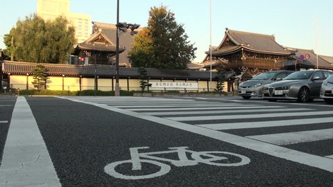 KYOTO, JAPAN - 26 OCTOBER 2012: Traffic makes its way through the streets of Kyoto in Japan with a classic temple in the background