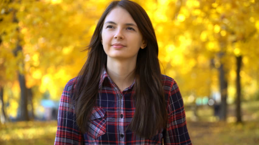 young girl walks in the park in autumn. Footage steadicam shot