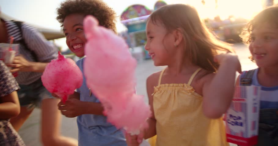 Multi-ethnic best friends children having fun eating cotton candy and pop-corn at summer funfair Royalty-Free Stock Footage #31710139