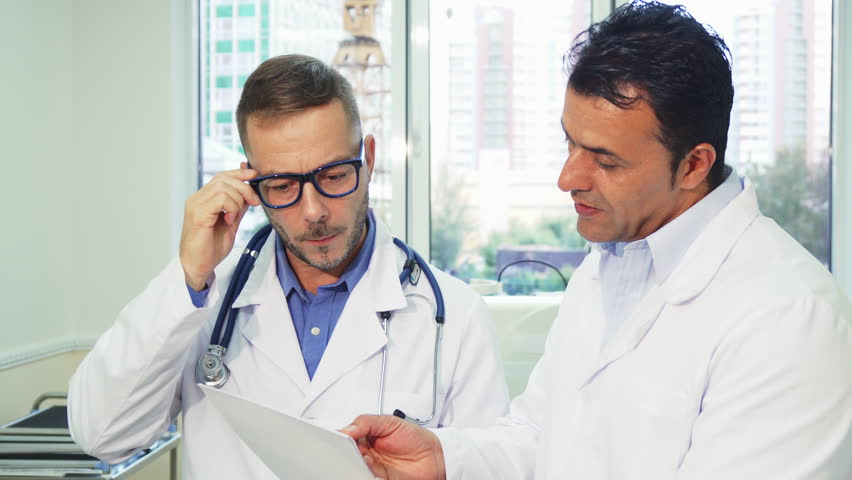 Doctors carefully study the patient’s medical certificate. They discuss this with each other. They look very serious and attentive. They are in the doctor's office