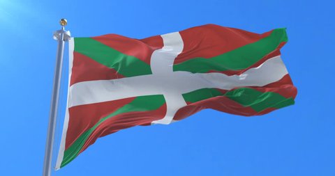 Basque country flag named Ikurriña moving slowly by the wind with blue sky, loop