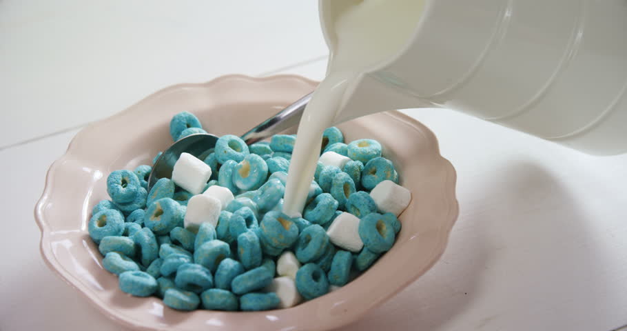 Close-up of milk being pour into cereal rings and marsh mallow 4k