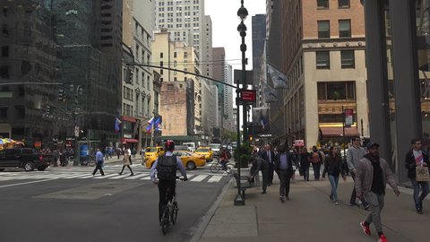 New York-circa 2017: Heavy traffic in the narrow streets of Manhattan, with stunning heights of blocks and bright advertising in the afternoon, on a sunny day, ultra hd4k, real time