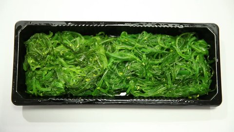 Healthy green seaweed salad isolated on white