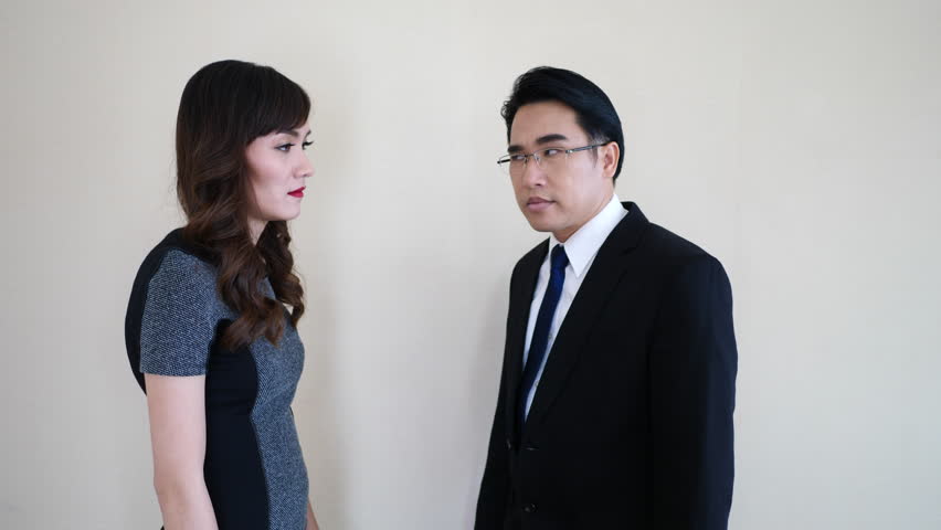 Two business people fighting in office hitting each other