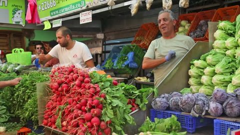 TEL AVIV, ISRAEL - SEPTEMBER 29, 2017: Carmel market. Vegetables sellers dancing during a holiday sale before Simchat Torah. On September 29, 2017 in Tel Aviv.