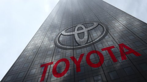 Toyota logo on a skyscraper facade reflecting clouds, time lapse. Editorial 3D rendering
